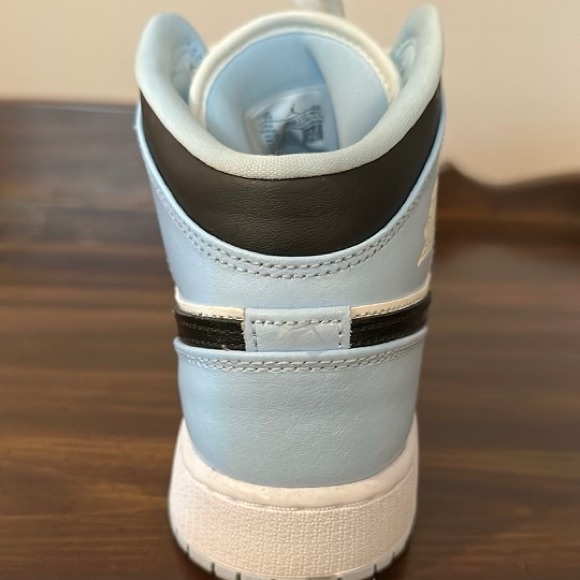 Jordan 1 Mids, size 7Y (middle school). Ice blue, white laces, black Nike logo